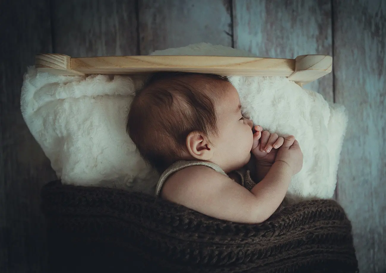 baby sleeping on a wool bed with a wool pillow