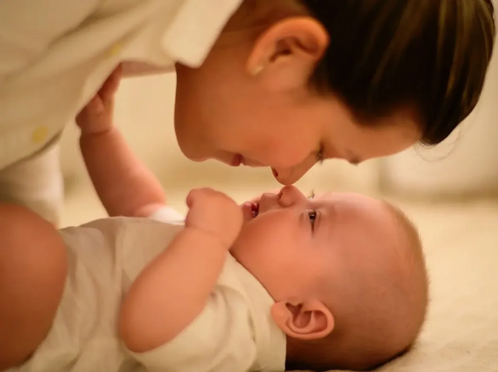 baby touching noses with its mom
