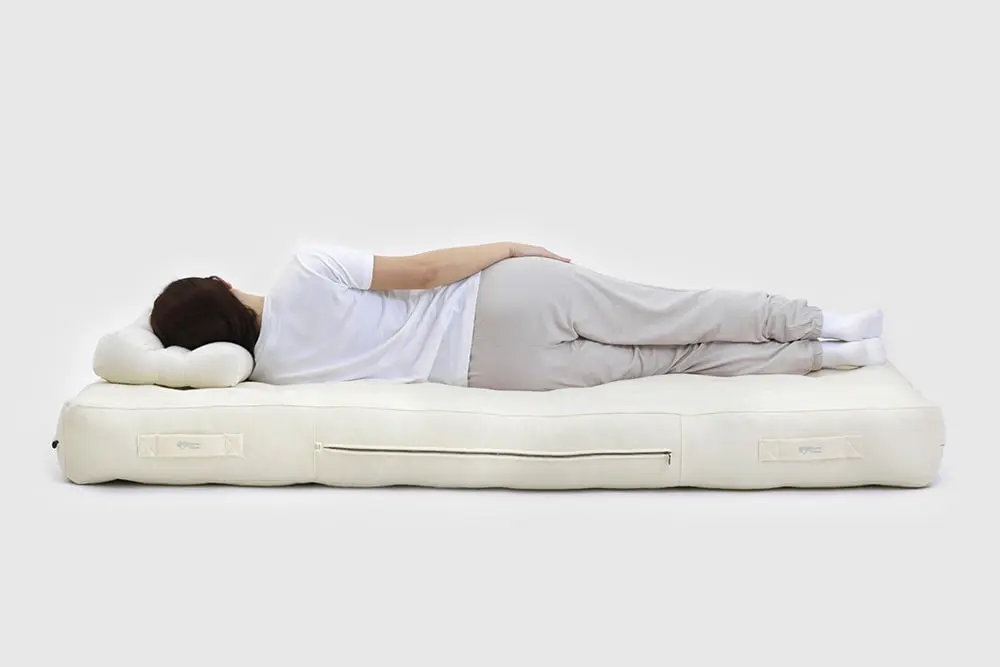 woman laying on a wool bed and a wool pillow