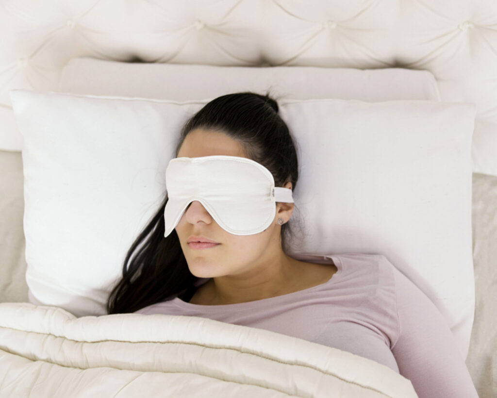 girl laying in bed with a home of wool sleep mask