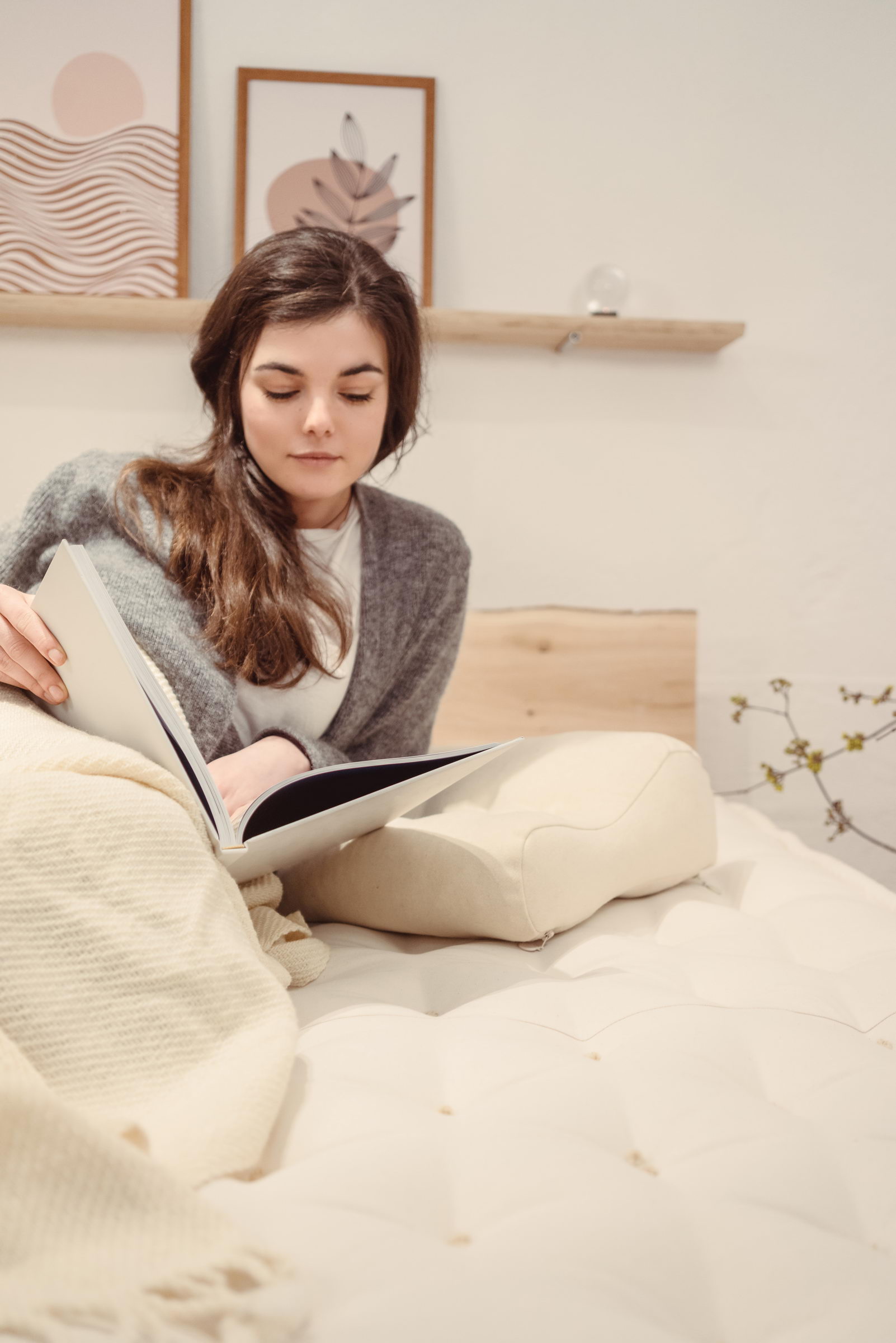 girl reading a book home of wool mattress ergonomic pillow and blanket