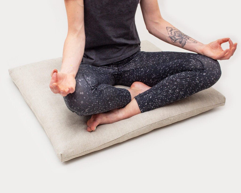 woman doing yoga on a home of wool zabuton