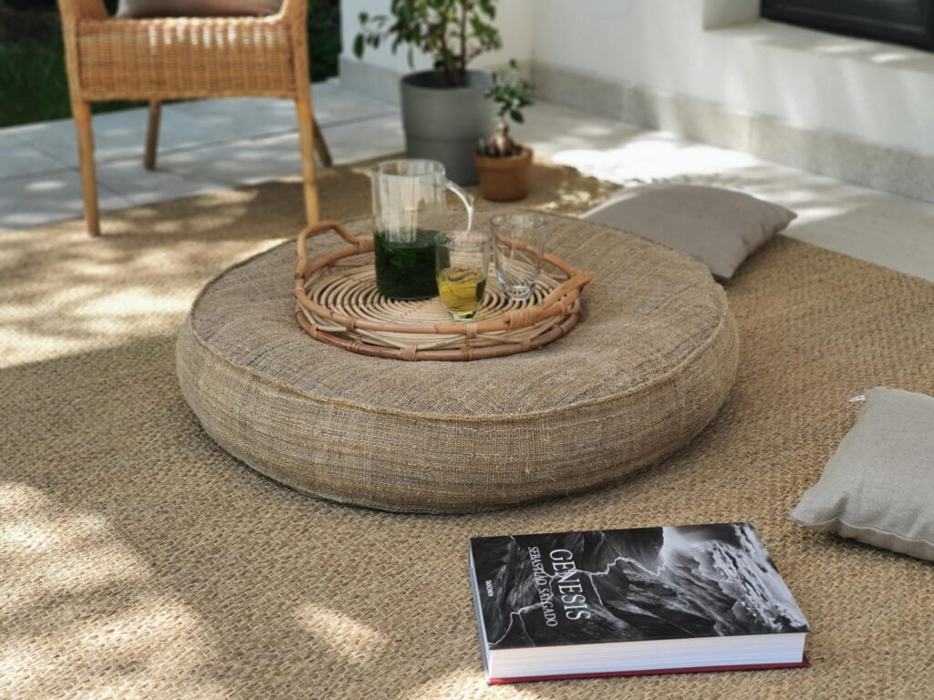 cozy setting with a wool round table, drinks, cushions and a soft lighting