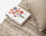 детайлен кадър на плат – ръчно тъкан ленен килим и книга