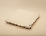 wool mattress protector on top of a mattress topper sample, flat